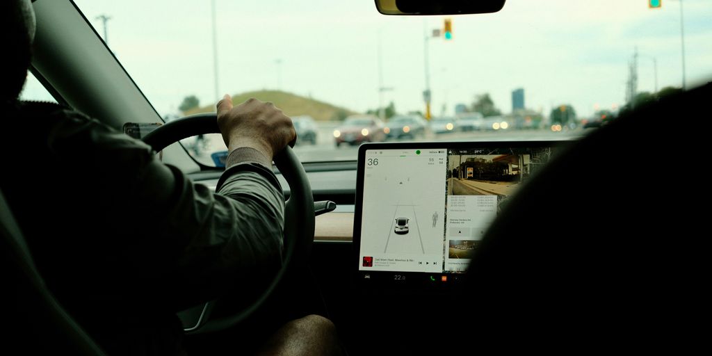 a man driving a car on a busy street
