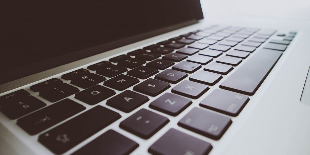 vintage computer and modern laptop with world map background