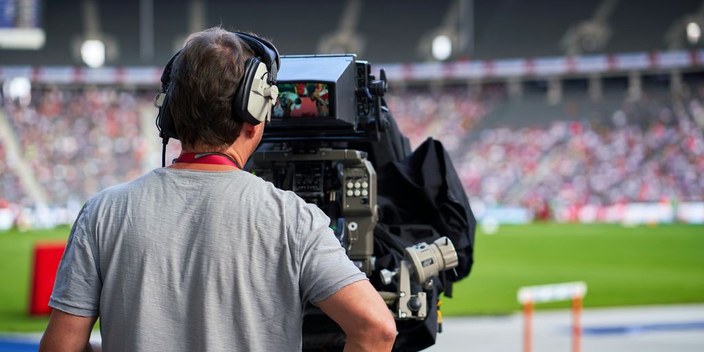 a man with headphones on sitting in front of a camera