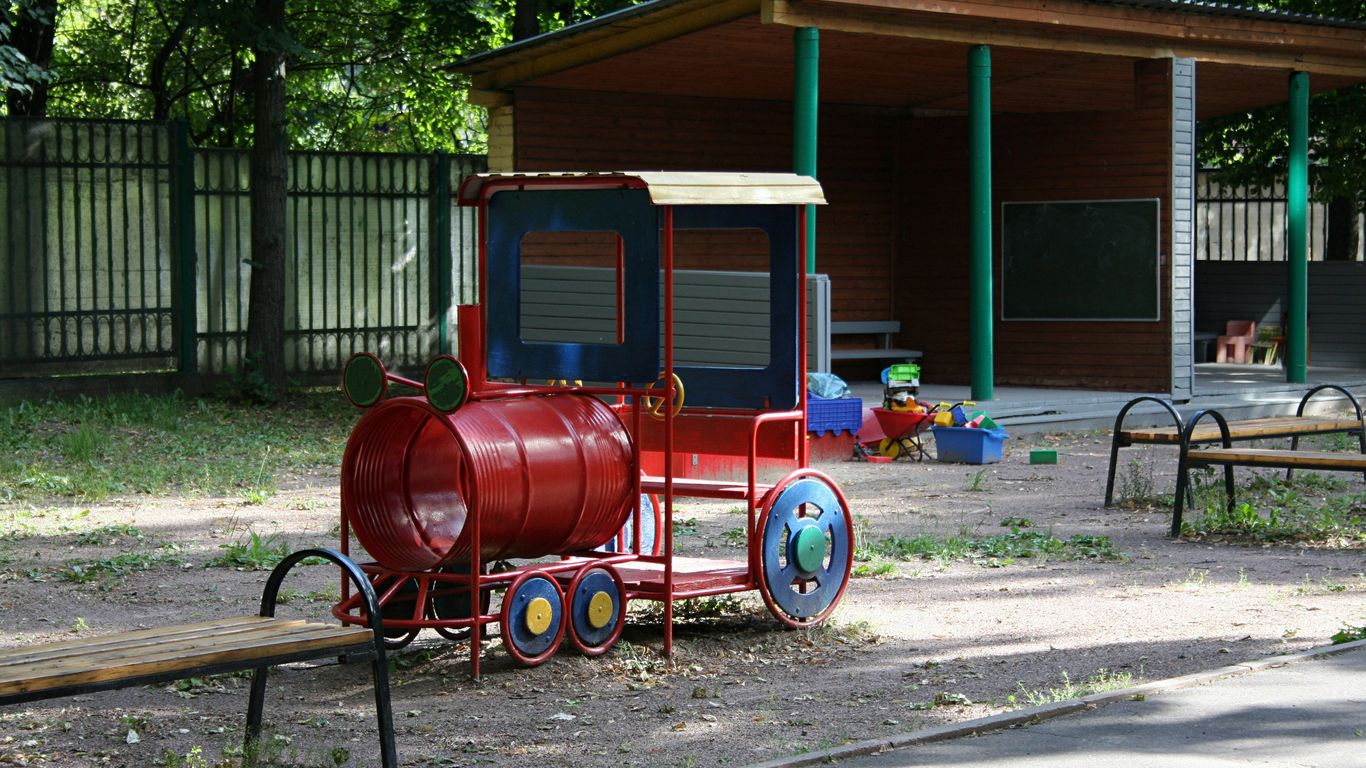 a red train sitting on top of a dirt field