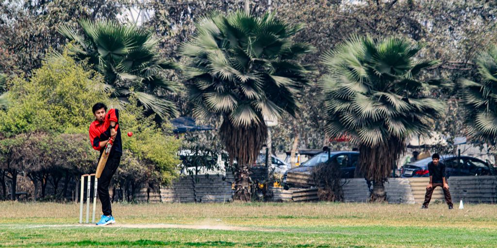 a man playing a game of cricket in a park