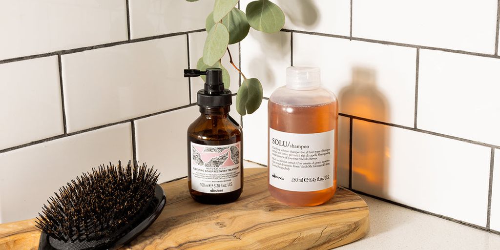 Bathroom shelf with haircare products and natural bristle brush.