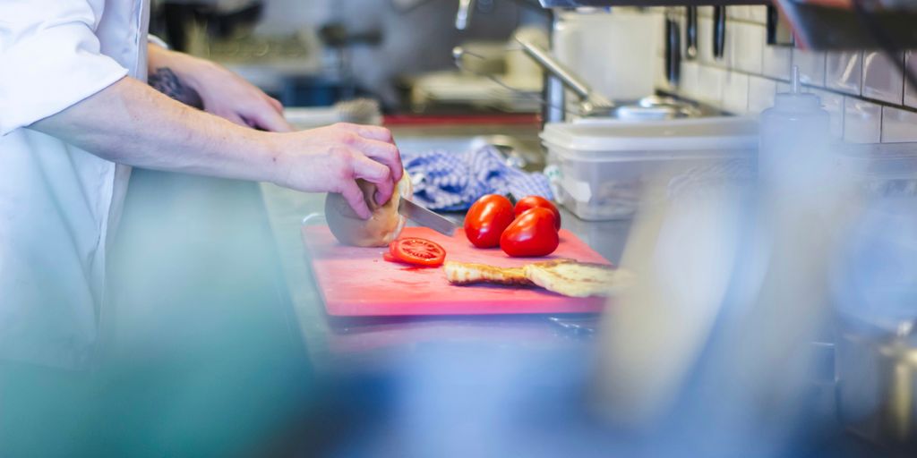 person slicing tomatoes