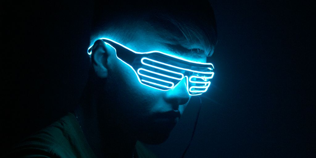 a man wearing a neon mask in the dark