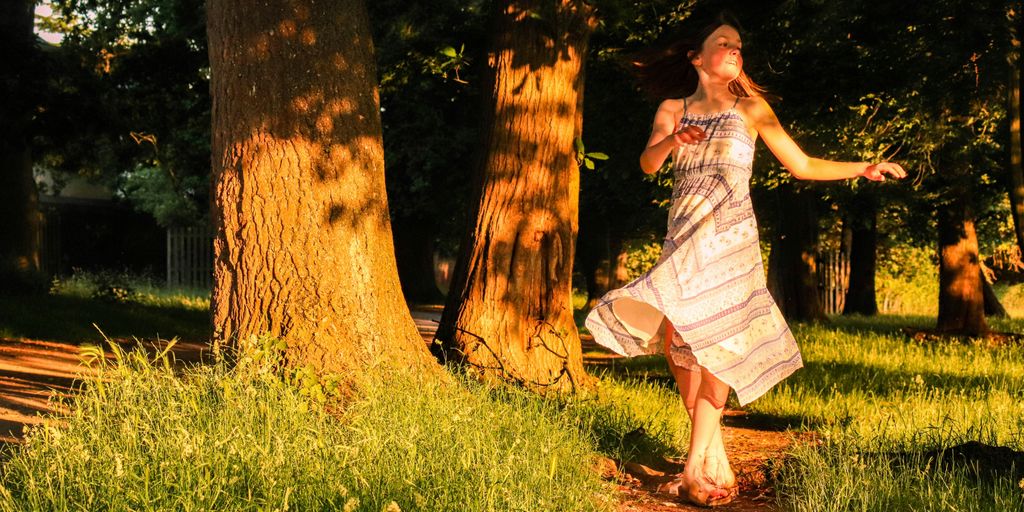 woman in white dress standing on green grass field during daytime
