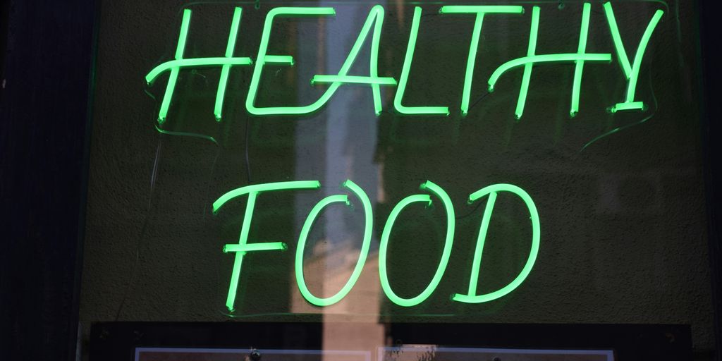 a green neon sign that says healthy food