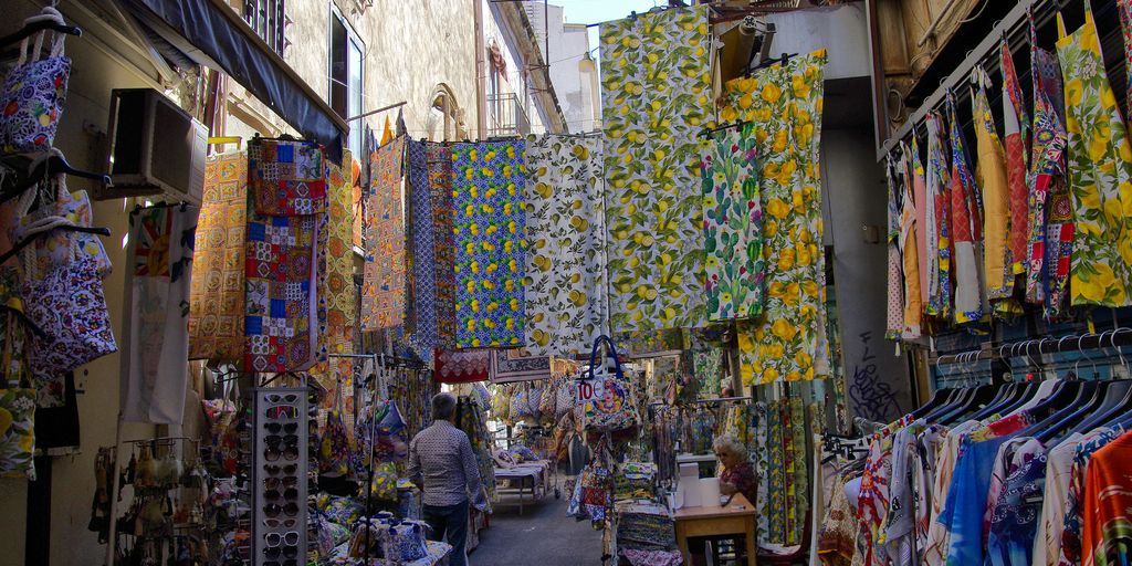 A man walking down a street next to a store