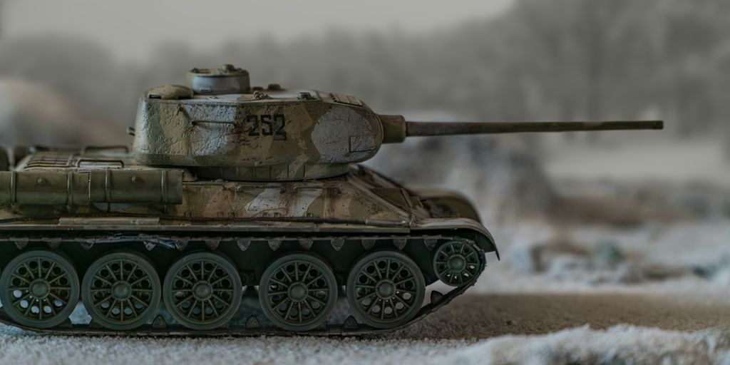 A toy tank sitting on top of a snow covered ground