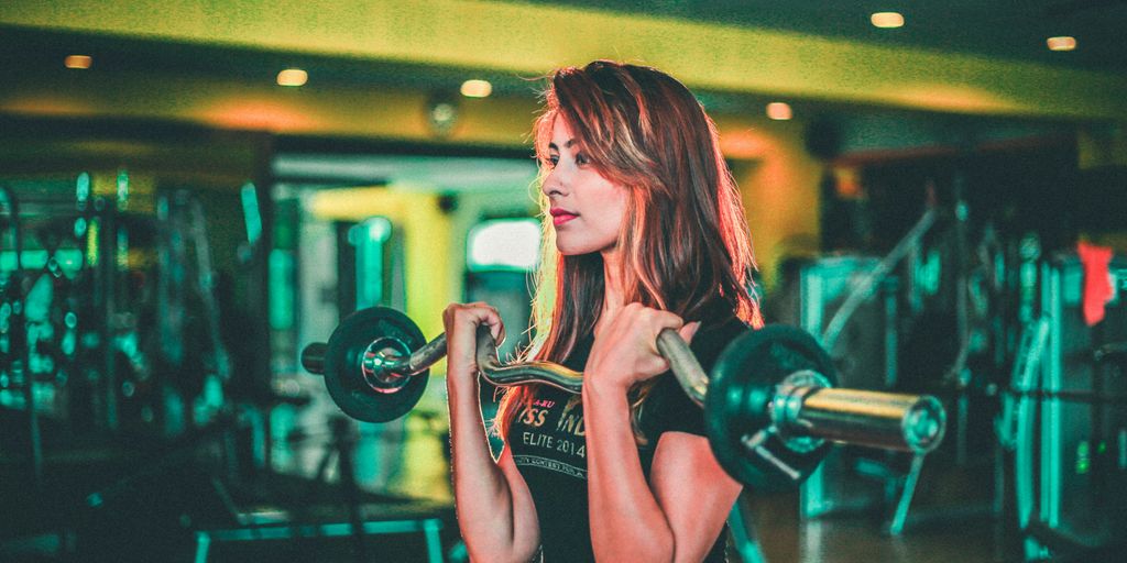 woman lifting black and gray barbell