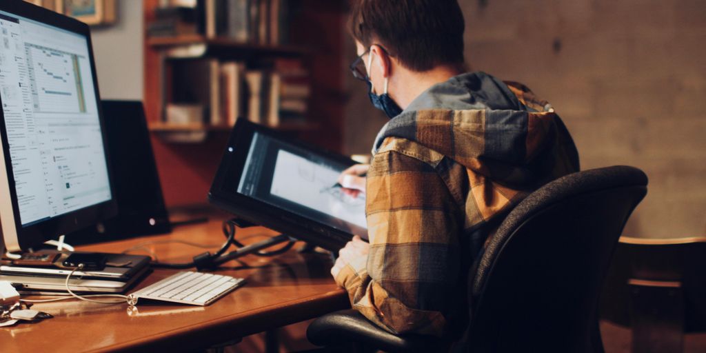 man in brown and white plaid dress shirt sitting on black office rolling chair