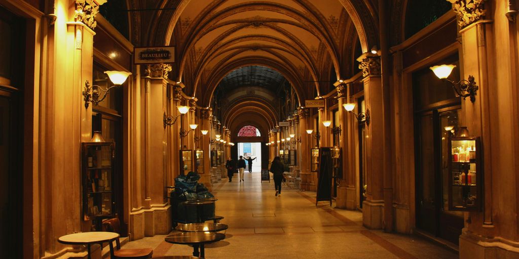 a long hallway with tables and lamps on either side of it