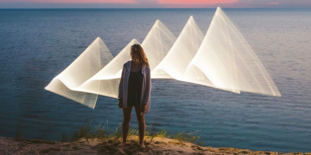 a woman standing on top of a beach next to the ocean