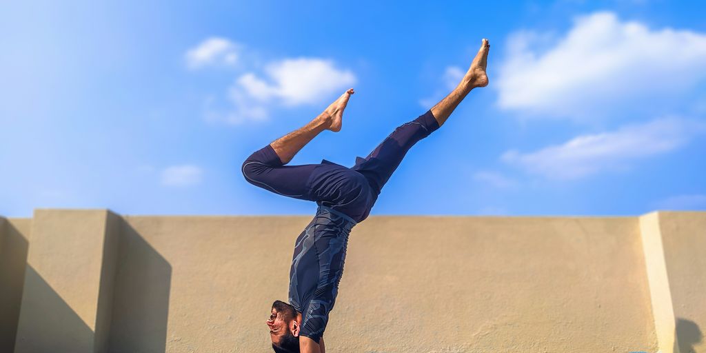man in black pants and black shirt standing on blue yoga mat