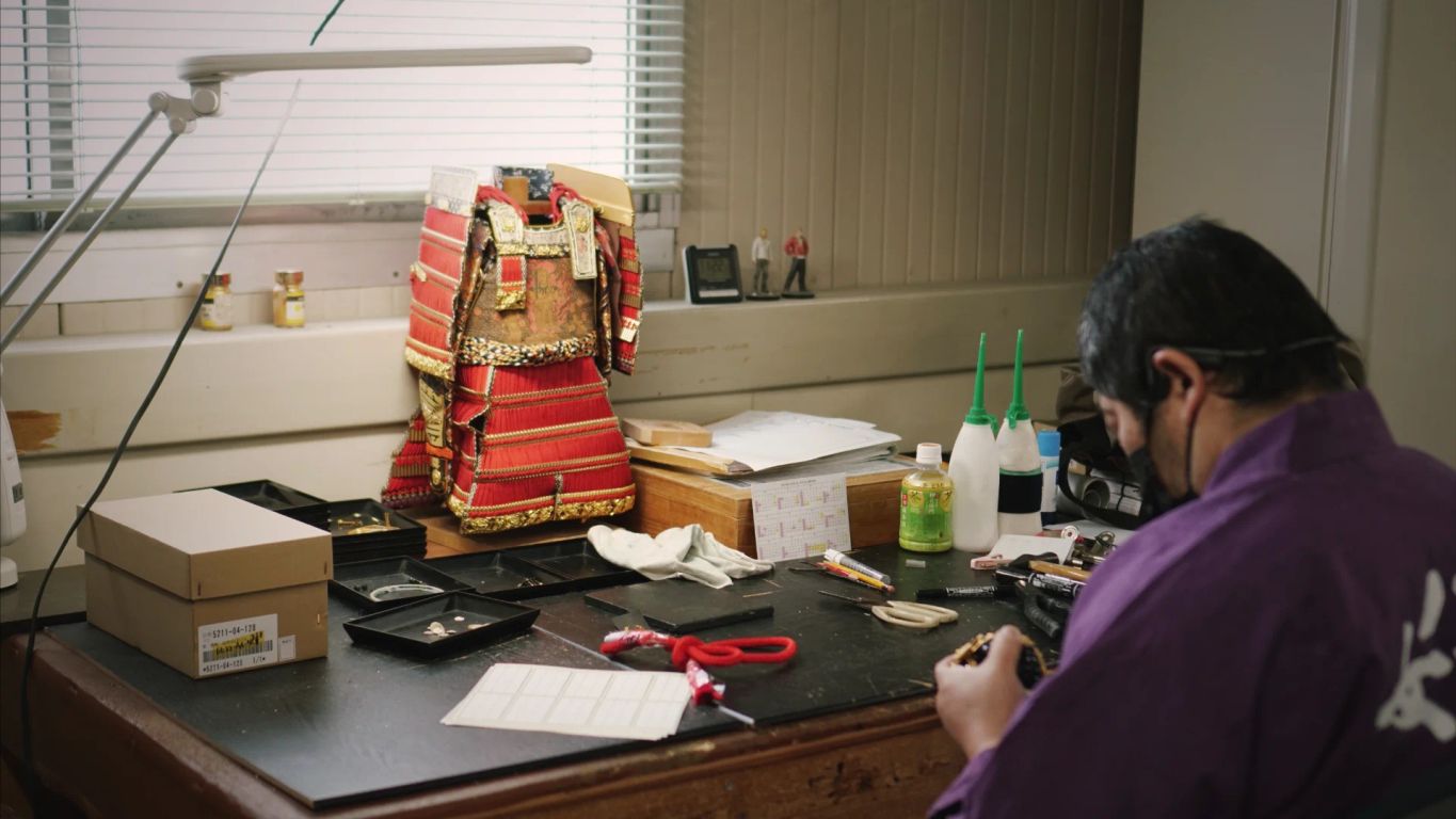 A workspace with tools and a traditional armor display.