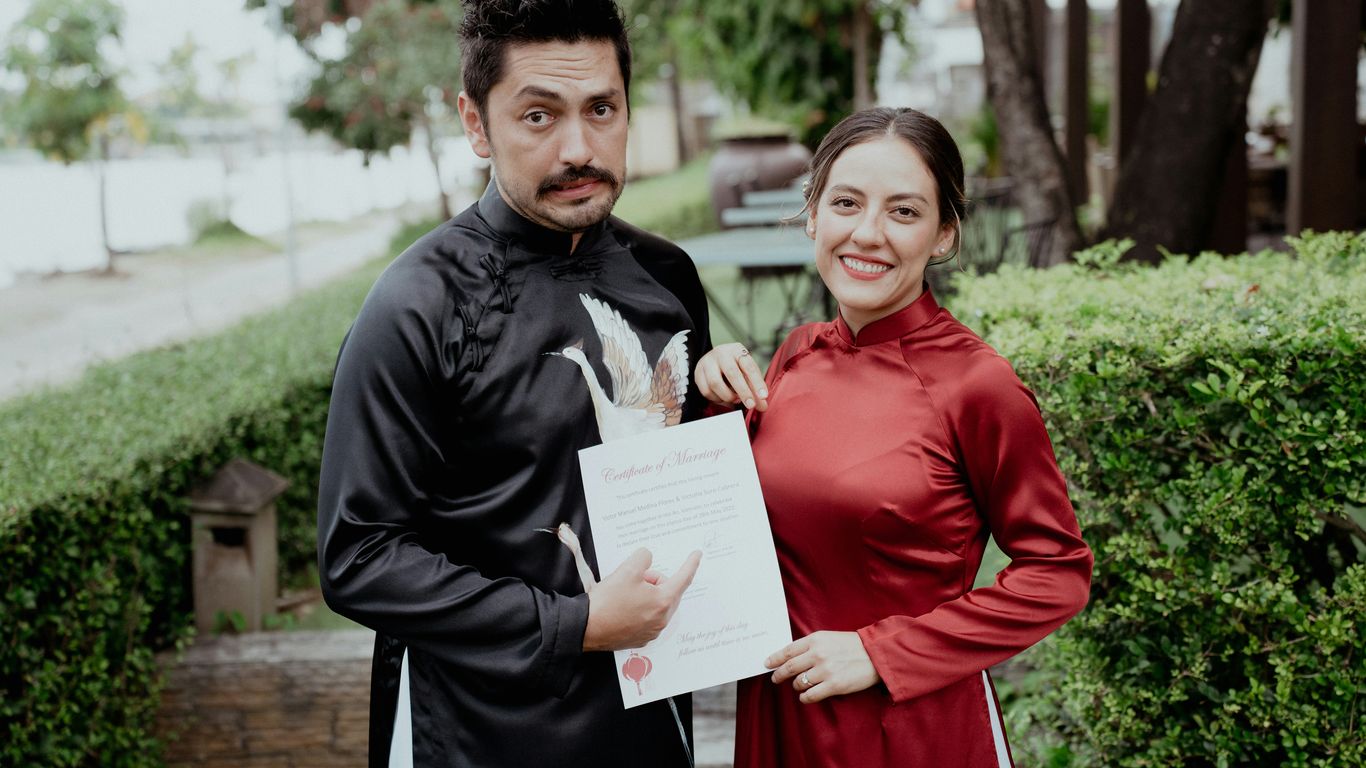 a man standing next to a woman in a red dress