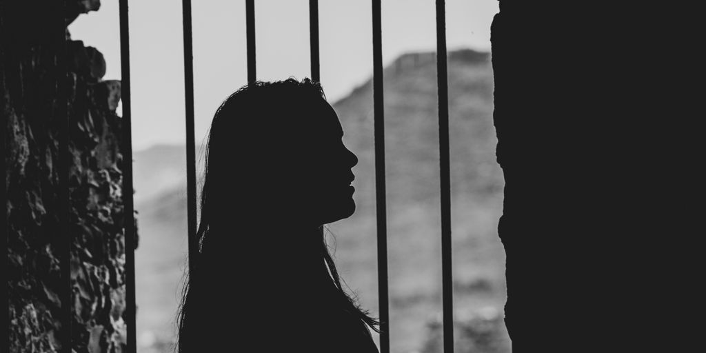 shadow of woman by the metal bar window