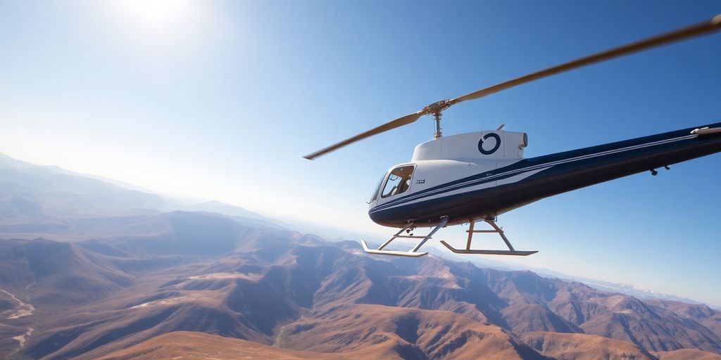 A Bell 206 Jet Ranger helicopter flying over mountains.