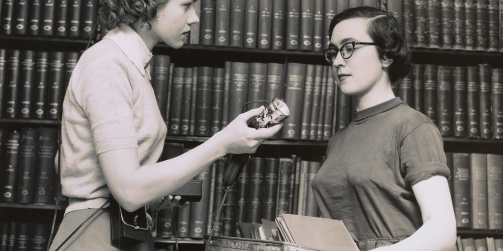 two women talking in the library 