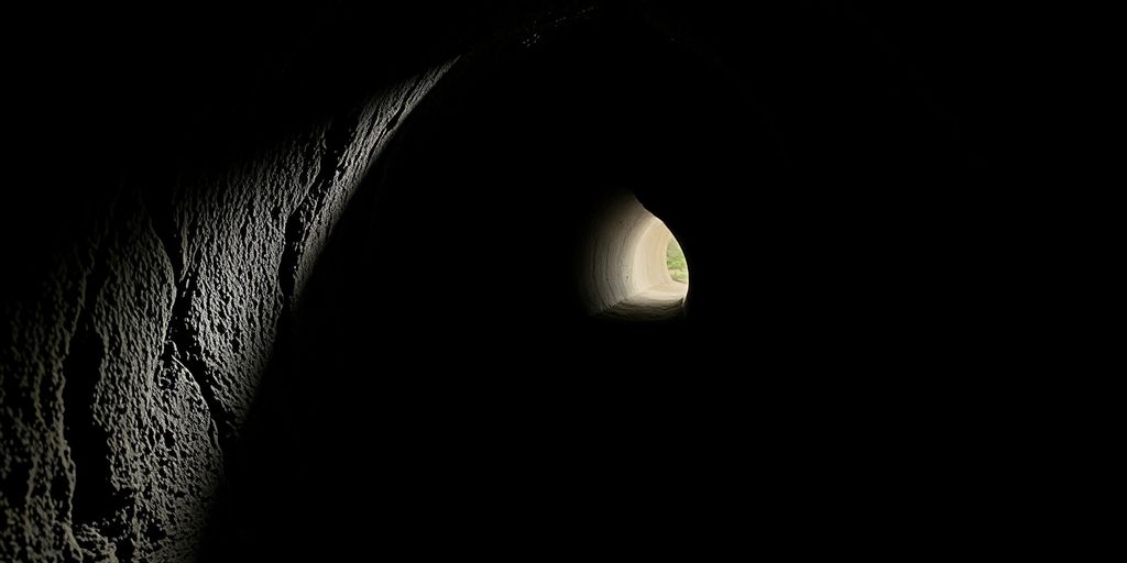 A dark tunnel leading to light, symbolizing exploration.