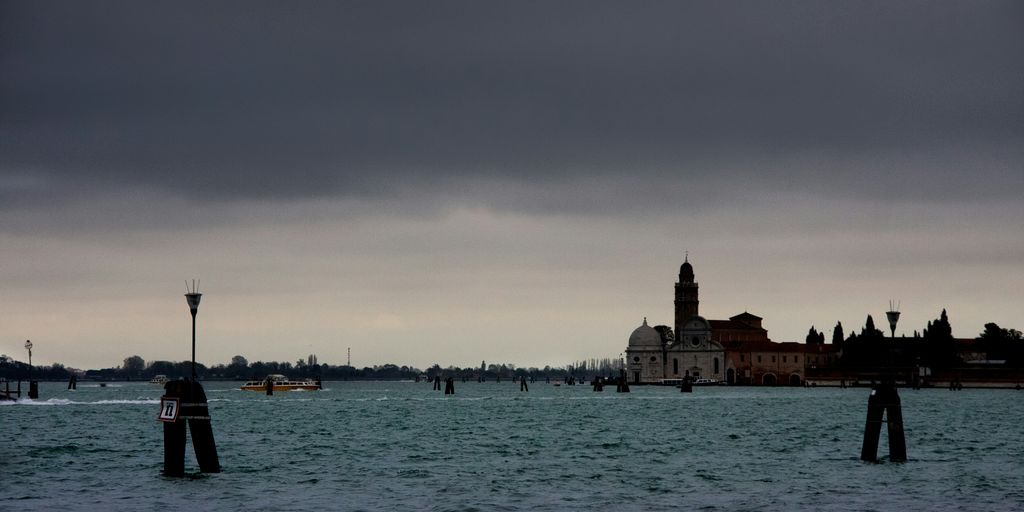 boat on sea near city buildings during daytime