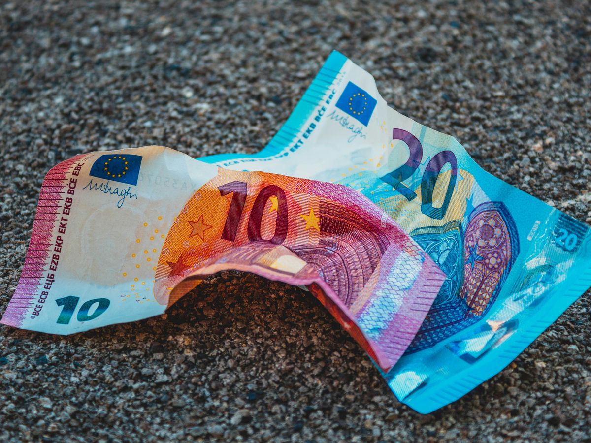 two 20 and 10 banknotes on gravels