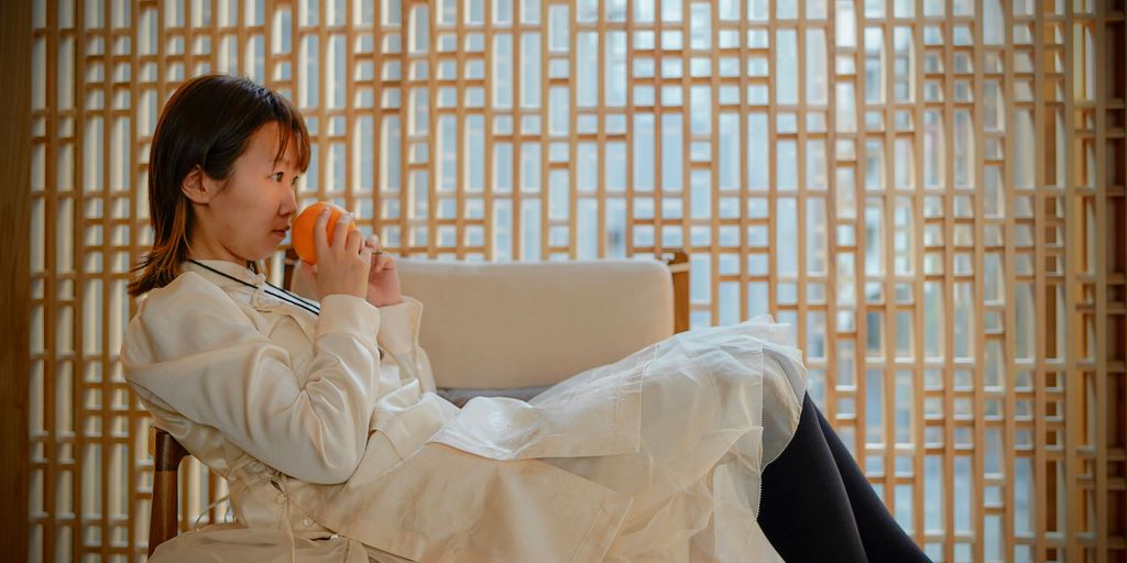 a woman sitting in a chair holding a cup of coffee