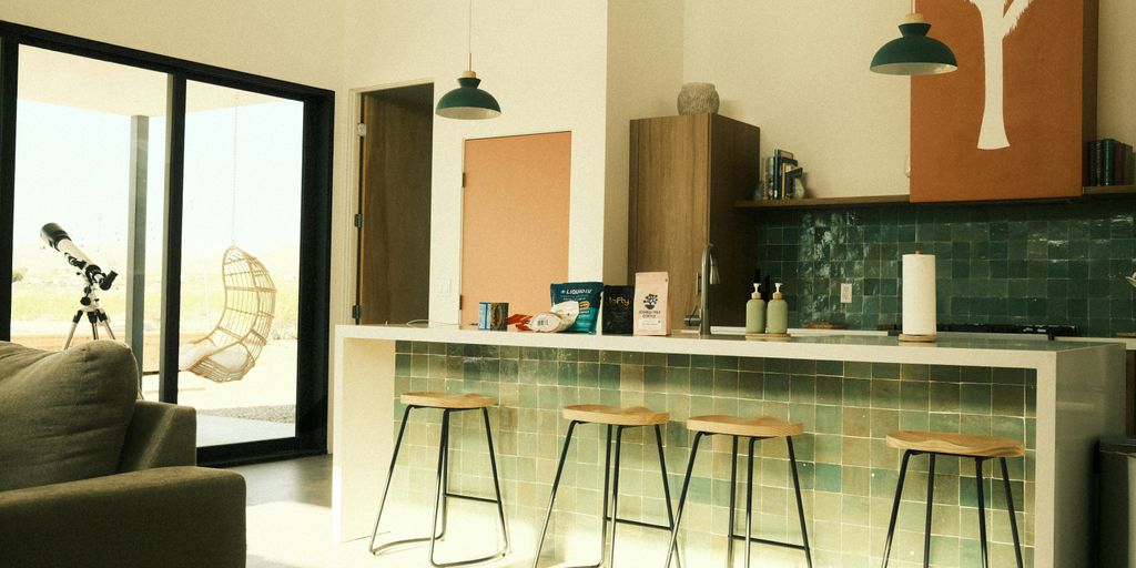 An interior shot shows a modern kitchen and living room.