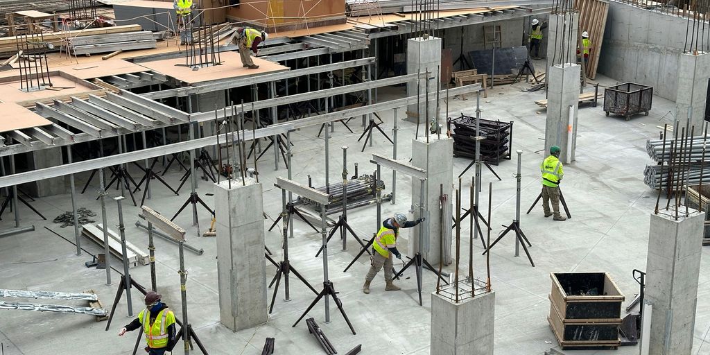 a group of men standing around a building under construction