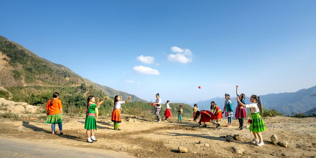 a group of people standing on top of a dirt field