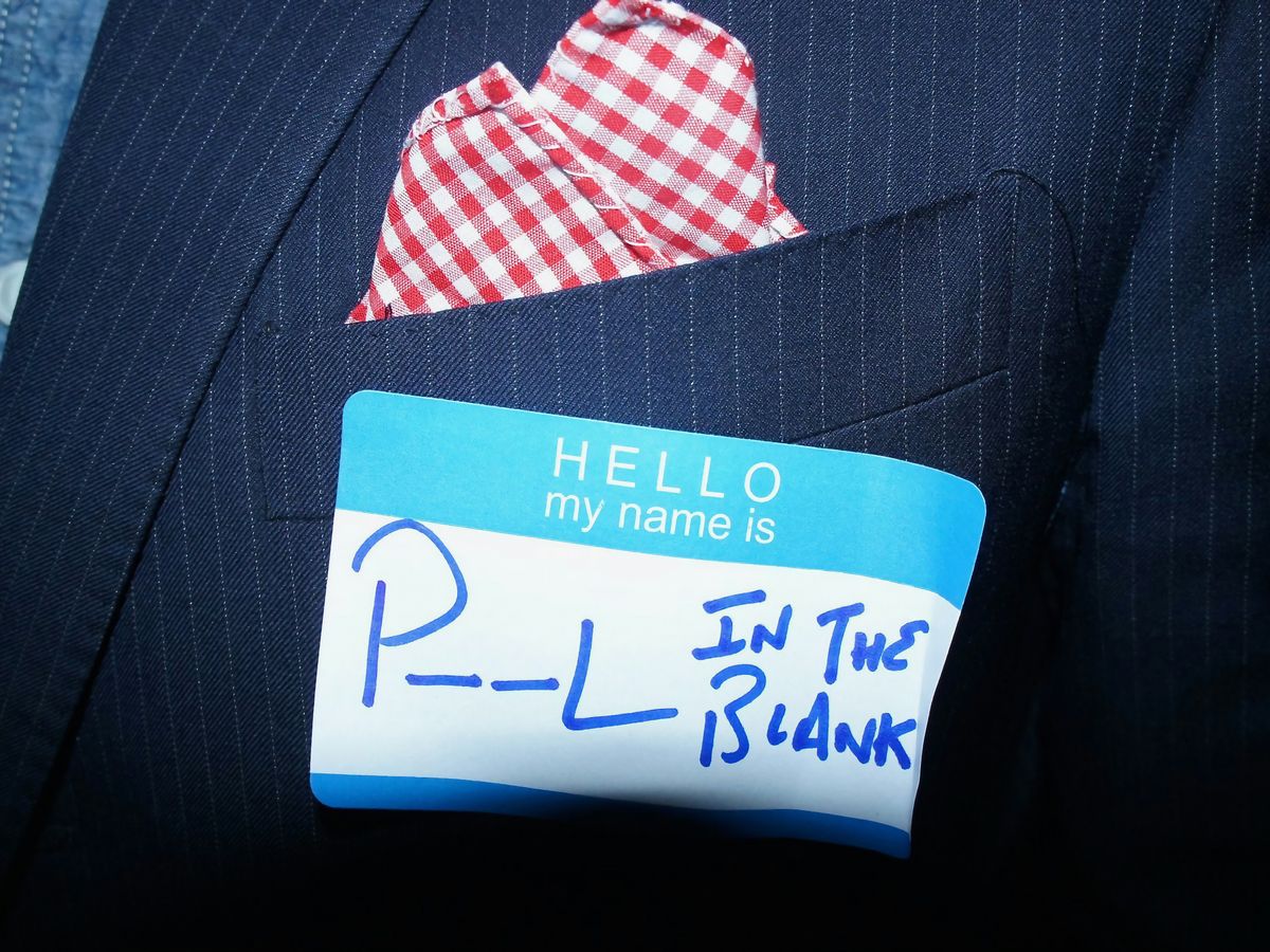 a close up of a person wearing a suit and tie