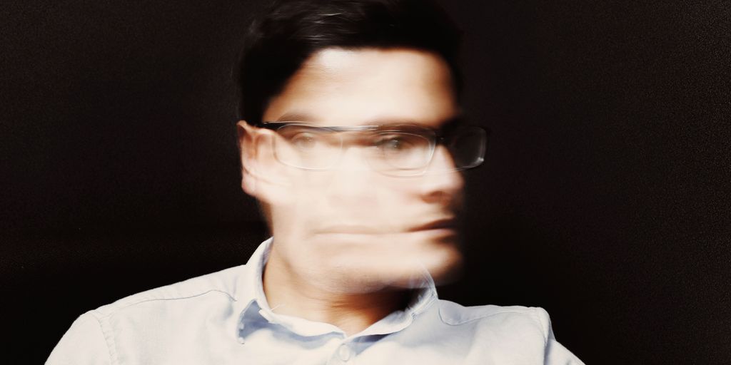 man wearing white button-up collared top and black framed eyeglasses
