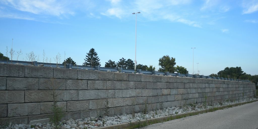 A long concrete wall next to a street