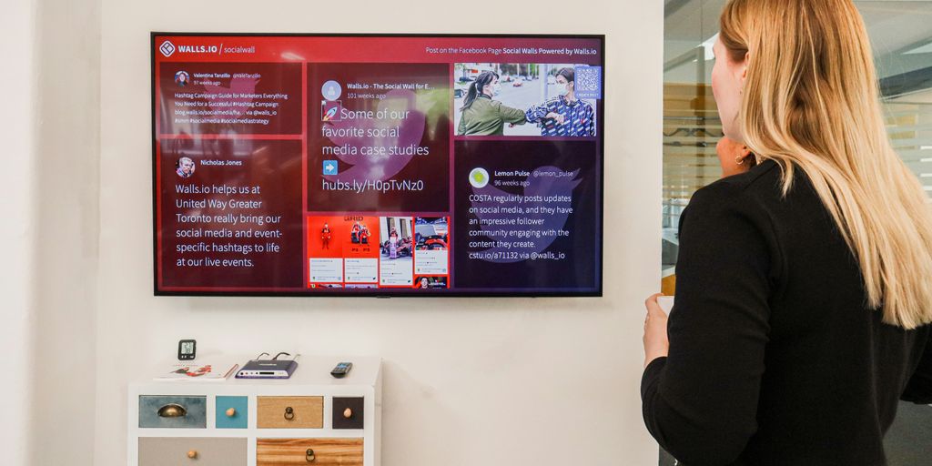 a woman standing in front of a large television