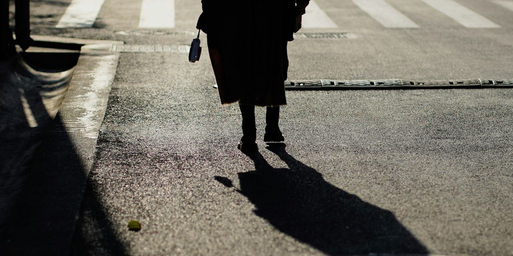 woman in black coat walking on the street during daytime