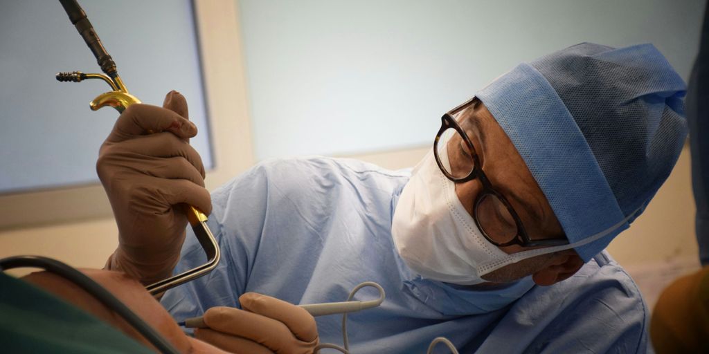 person in blue hijab holding black smartphone