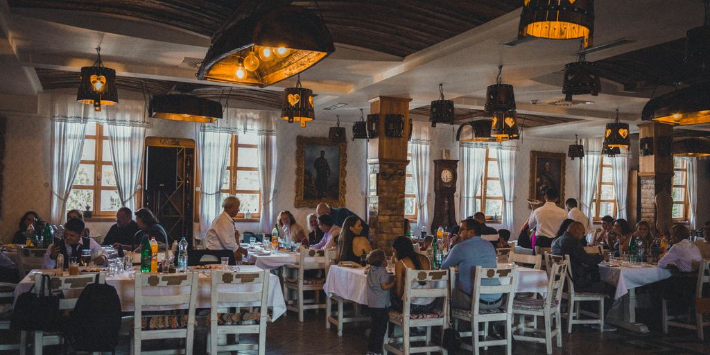 a group of people sitting at tables in a restaurant
