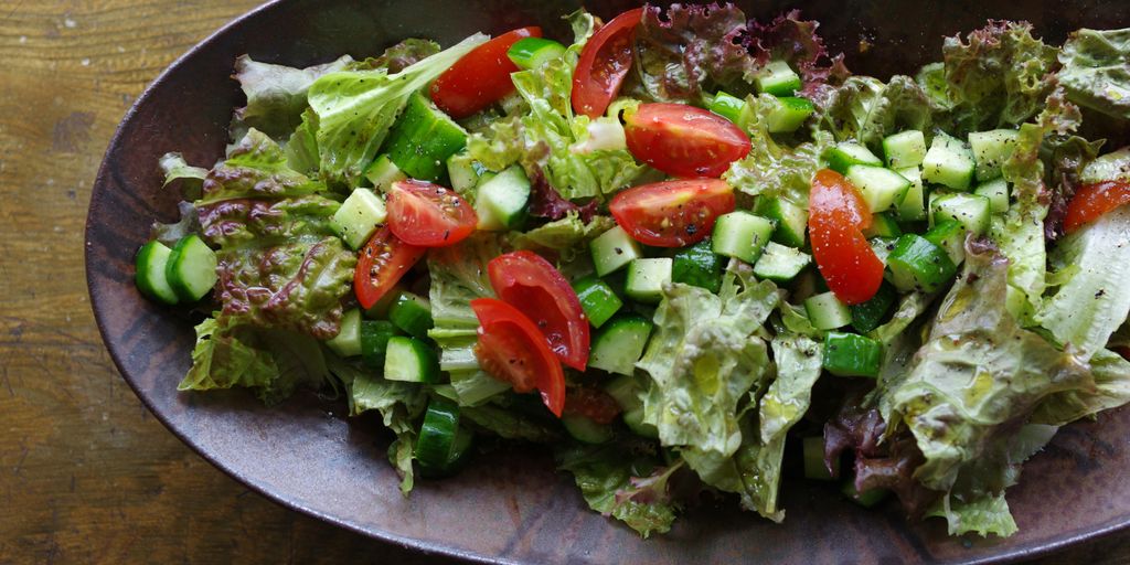 A bowl of salad on a wooden table