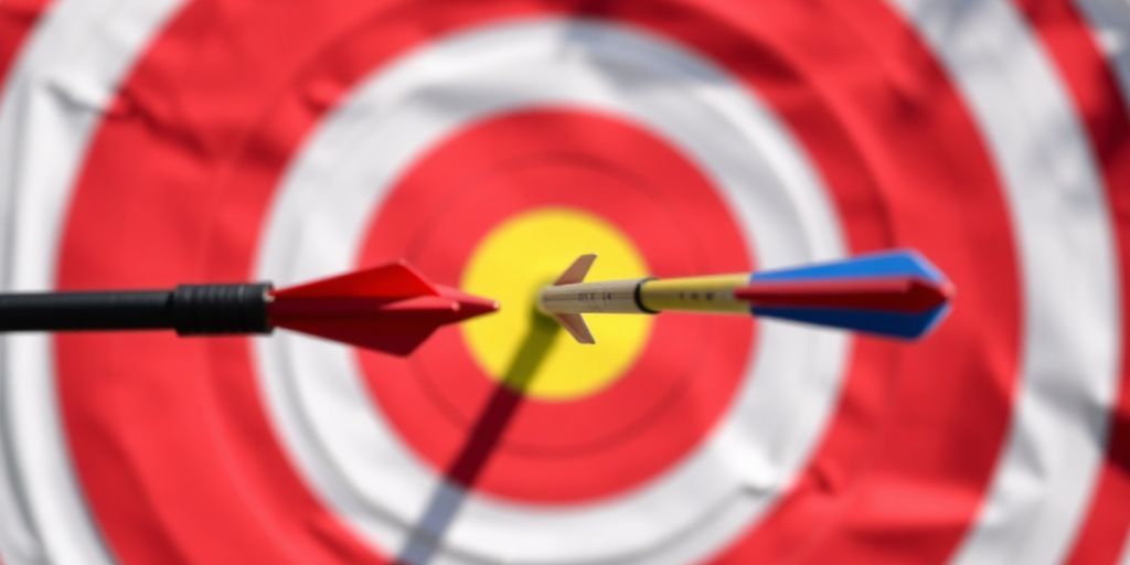 Archery target with bullseye, arrows striking center