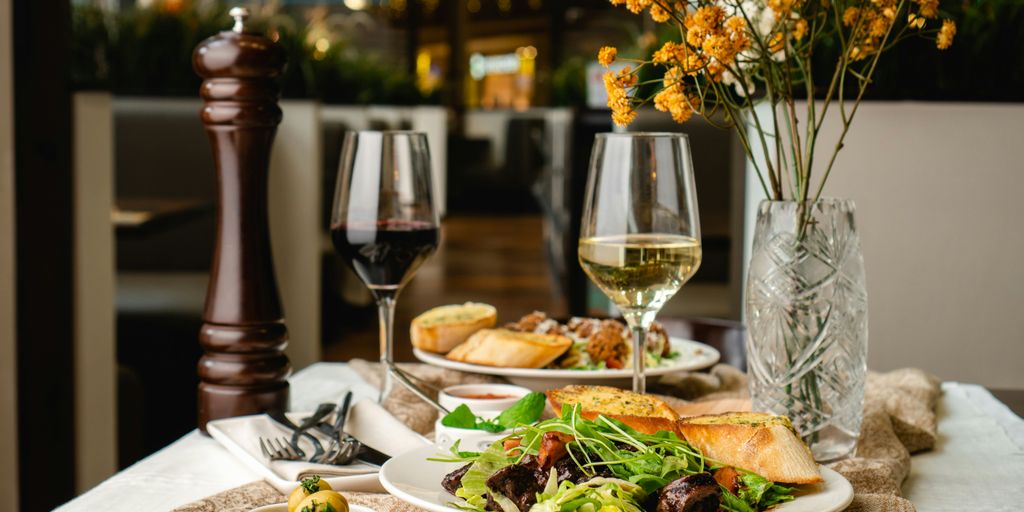 a table topped with plates of food and glasses of wine