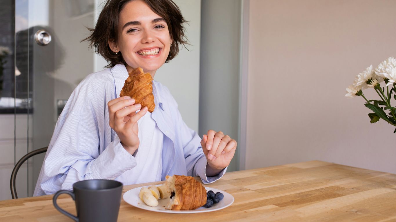 a woman sitting at a table with a plate of food