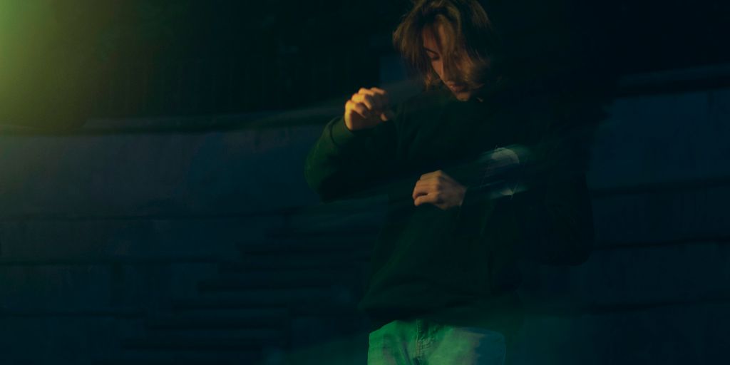 a man standing in front of a green light
