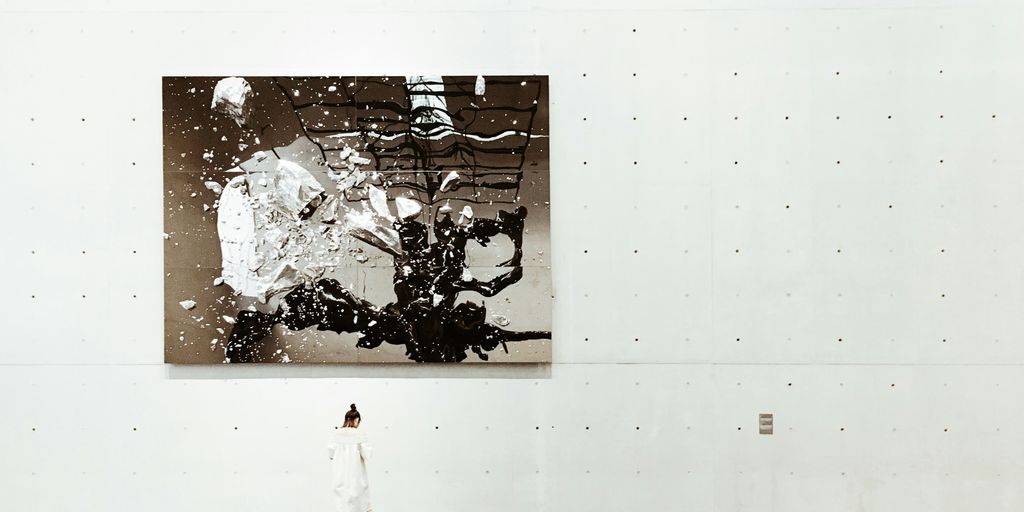 A woman standing near a painting in a modern art gallery