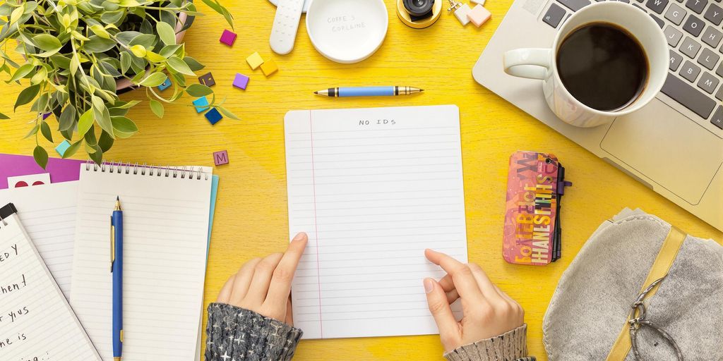 Büro mit Laptop, Kaffeetasse und Notizbuch
