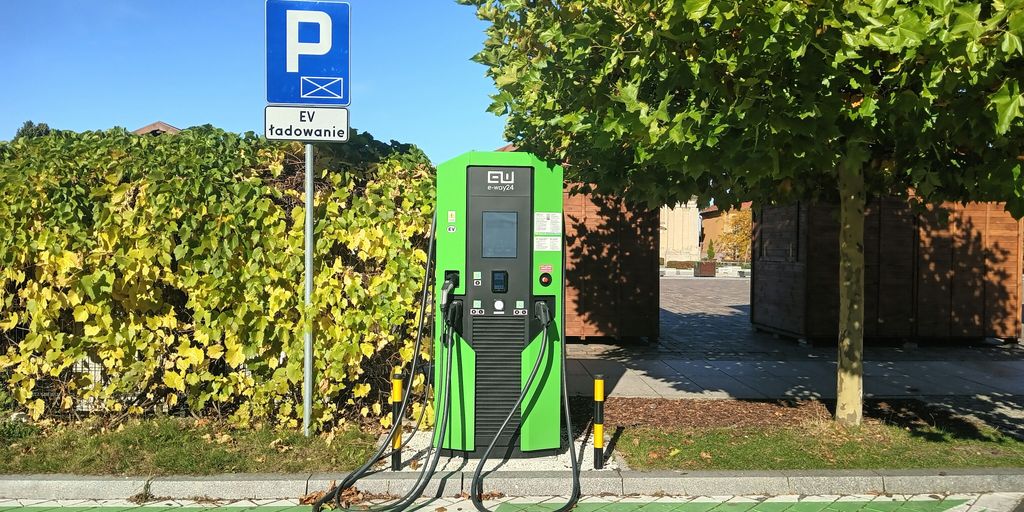 A green gas pump sitting on the side of a road