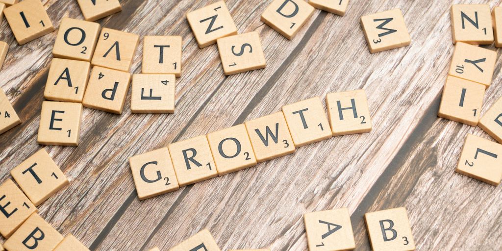 scrabbled letters spelling growth on a wooden surface