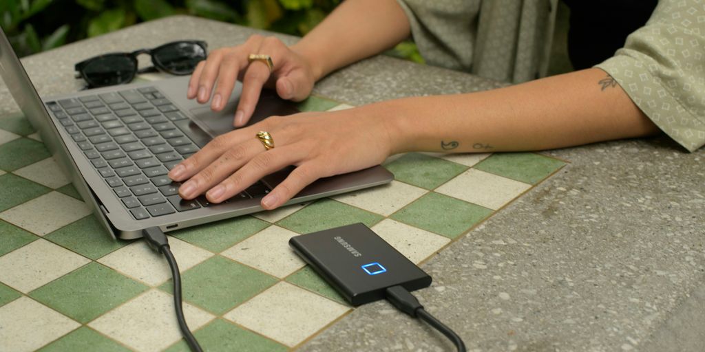 A woman typing on a laptop on a table