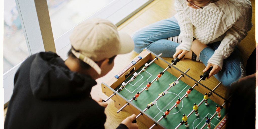man and woman playing foosball table