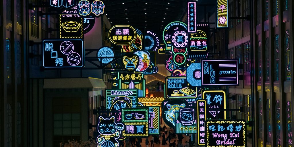 A group of people walking through a mall filled with neon signs