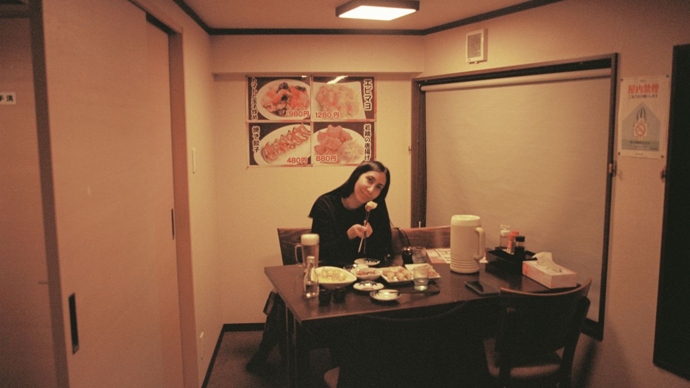 Woman enjoys a meal at a table in a restaurant.