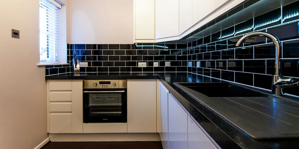 a kitchen with a black counter top and white cabinets